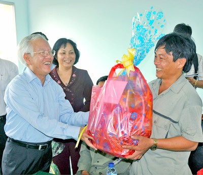 Chairman of the Ho Chi Minh City People’s Committee Le Hoang Quan (L) offers gifts to Le Minh Hoang, a forest security guard in An Thoi Dong Commune, Can Gio District. (Photo: SGGP) Chairman of the Ho Chi Minh City People’s Committee Le Hoang Quan (L) offers gifts to Le Minh Hoang, a forest security guard in An Thoi Dong Commune, Can Gio District. (Photo: SGGP)
